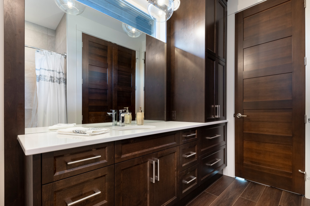Medium sized classic family bathroom in Vancouver with recessed-panel cabinets, dark wood cabinets, a built-in bath, wood-effect tiles, a built-in sink, engineered stone worktops, brown floors, white worktops, a single sink and a built in vanity unit.