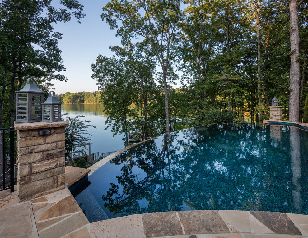 This is an example of a traditional backyard custom-shaped infinity pool in Atlanta.