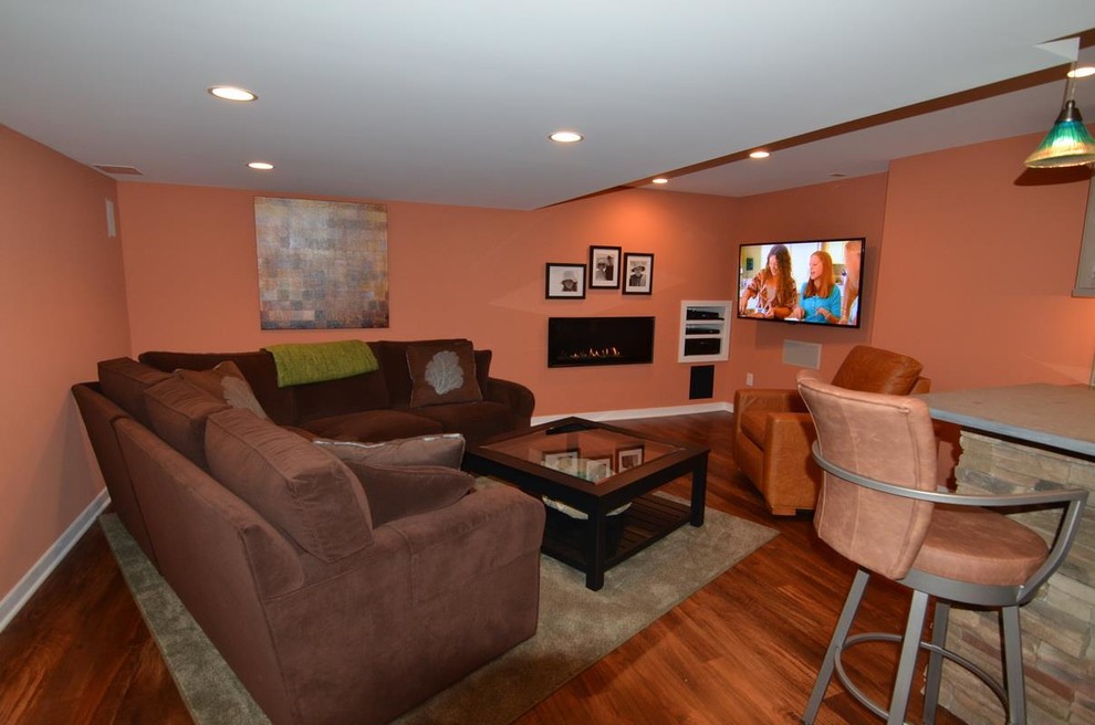 Large contemporary open concept home theatre in Philadelphia with orange walls, medium hardwood floors and a wall-mounted tv.
