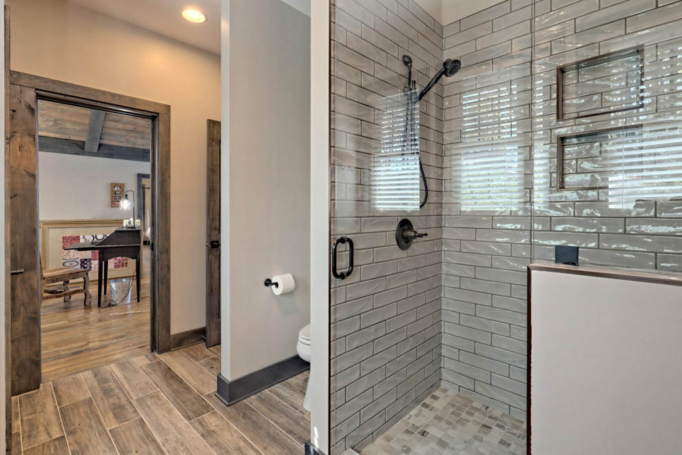 Idéer för att renovera ett mellanstort amerikanskt brun brunt badrum med dusch, med skåp i shakerstil, skåp i mellenmörkt trä, en dusch i en alkov, en toalettstol med separat cisternkåpa, grå kakel, tunnelbanekakel, grå väggar, klinkergolv i keramik, ett undermonterad handfat, granitbänkskiva, brunt golv och dusch med gångjärnsdörr