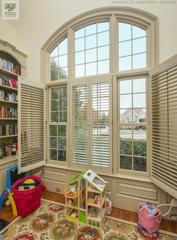 Esempio di una cameretta per bambini di medie dimensioni con pareti beige, pavimento in legno massello medio e soffitto a volta