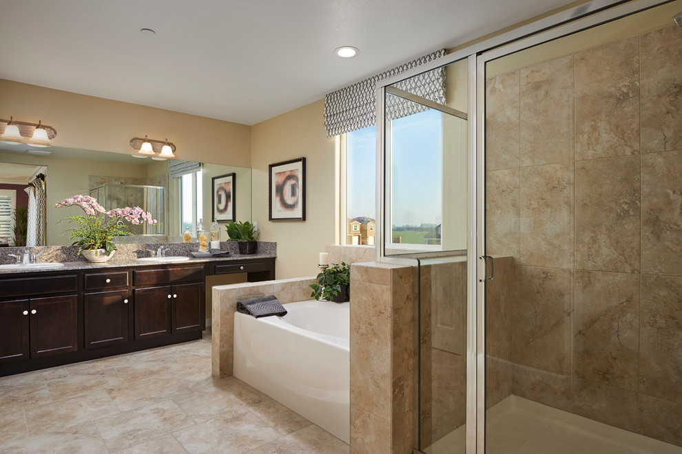 Example of a transitional beige tile and ceramic tile beige floor bathroom design with dark wood cabinets, beige walls and granite countertops