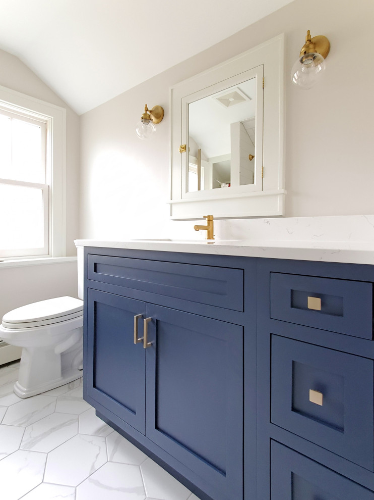 Photo of a mid-sized arts and crafts kids bathroom in Chicago with shaker cabinets, blue cabinets, an alcove tub, a shower/bathtub combo, a two-piece toilet, white tile, subway tile, white walls, porcelain floors, an undermount sink, engineered quartz benchtops, white floor, a shower curtain, white benchtops, a niche, a single vanity and a built-in vanity.