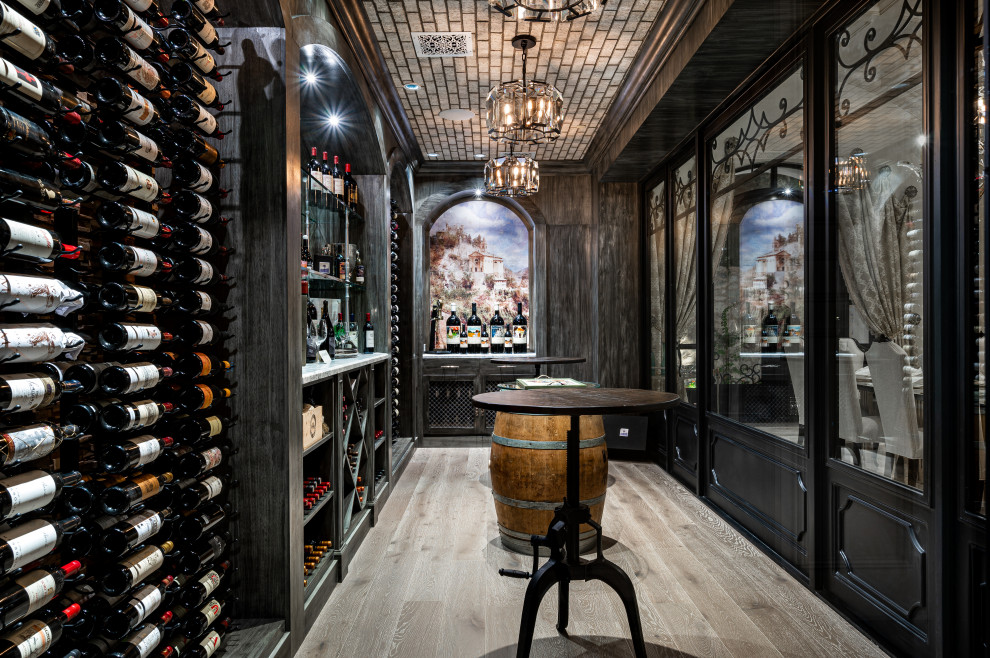 Photo of an expansive wine cellar in Phoenix with light hardwood flooring and display racks.