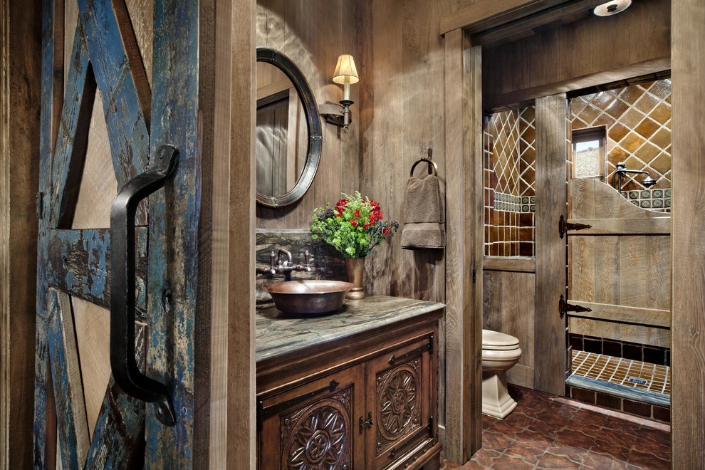 Design ideas for a mid-sized country 3/4 bathroom in Denver with furniture-like cabinets, dark wood cabinets, an open shower, a two-piece toilet, brown tile, cement tile, brown walls, cement tiles, a vessel sink, engineered quartz benchtops, red floor and a hinged shower door.