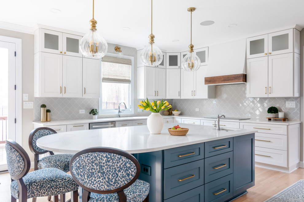 Large transitional light wood floor and brown floor eat-in kitchen photo with shaker cabinets, quartz countertops, gray backsplash, an island and a drop-in sink