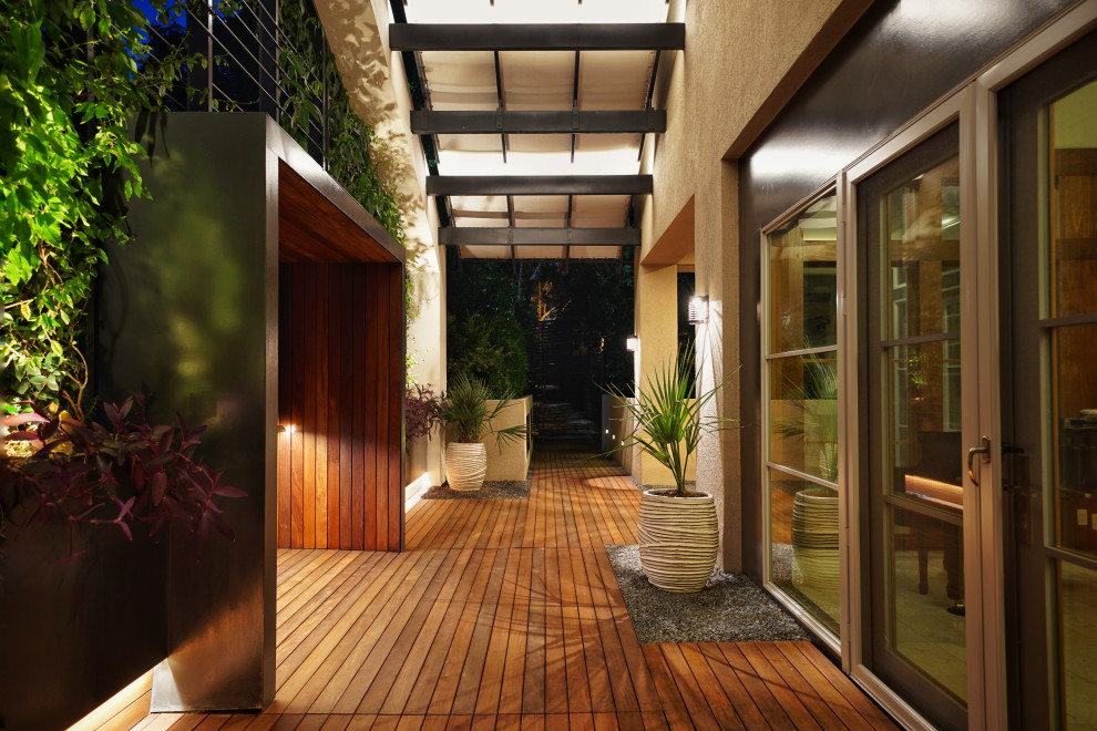 Inspiration for a small modern front yard patio in Austin with a container garden, decking and an awning.