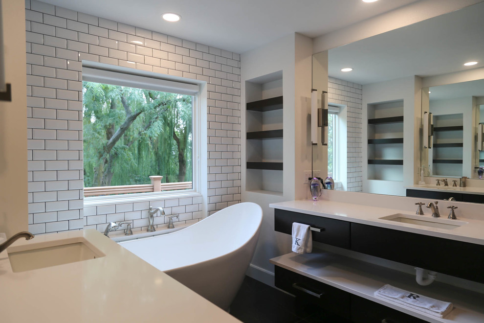 Inspiration for a mid-sized transitional master white tile and subway tile porcelain tile and black floor freestanding bathtub remodel with flat-panel cabinets, dark wood cabinets, a two-piece toilet, white walls, an undermount sink, quartzite countertops, a hinged shower door and white countertops