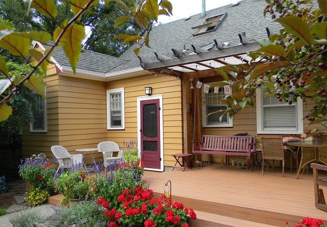 This is an example of a small arts and crafts backyard deck in Portland with a pergola.