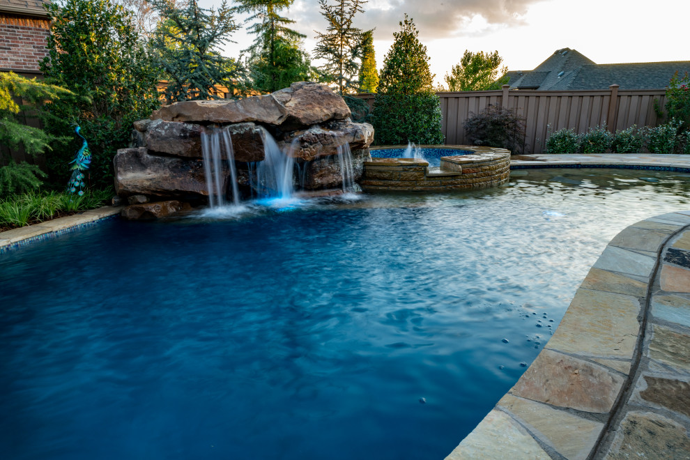 На фото: естественный ландшафтный бассейн среднего размера, произвольной формы на заднем дворе в стиле неоклассика (современная классика) с покрытием из каменной брусчатки