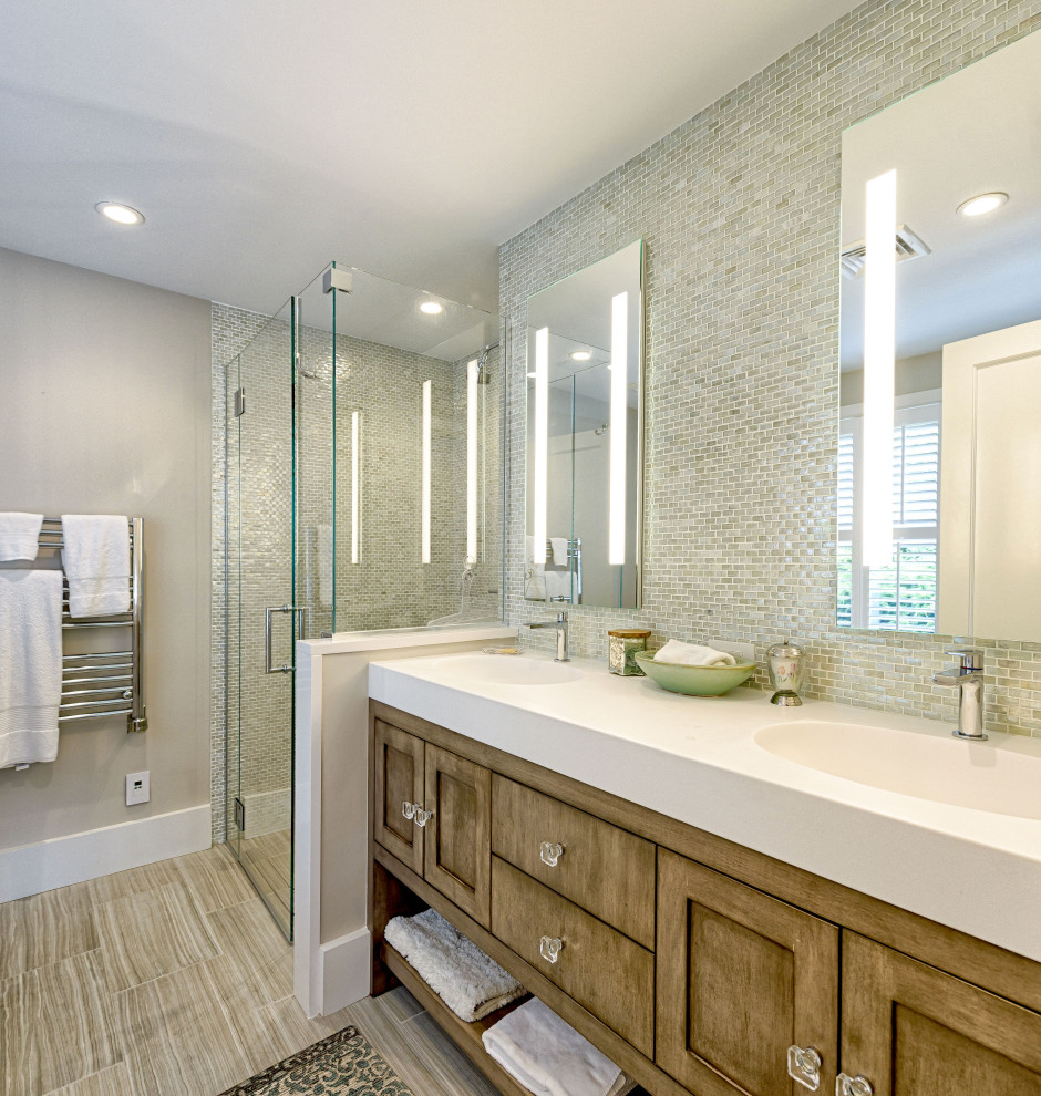 Photo of a transitional bathroom in Boston with shaker cabinets, medium wood cabinets, an alcove shower, multi-coloured tile, matchstick tile, beige walls, wood-look tile, an integrated sink, beige floor, a hinged shower door, white benchtops and a double vanity.