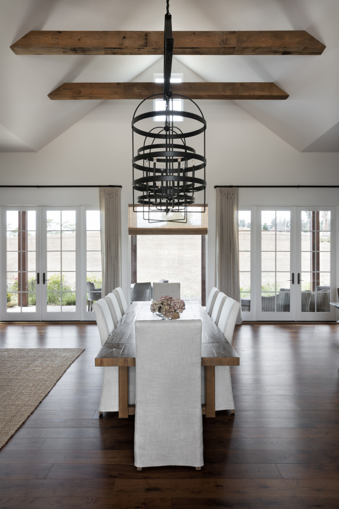 Inspiration for a country dining room in San Francisco with white walls, medium hardwood floors, a standard fireplace, a plaster fireplace surround and vaulted.