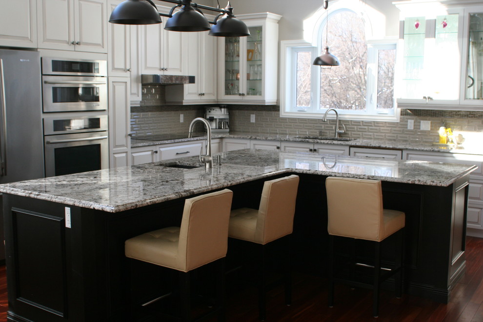 Inspiration for a huge transitional l-shaped medium tone wood floor and brown floor open concept kitchen remodel in Montreal with an undermount sink, glass-front cabinets, white cabinets, granite countertops, gray backsplash, ceramic backsplash, stainless steel appliances, an island and multicolored countertops