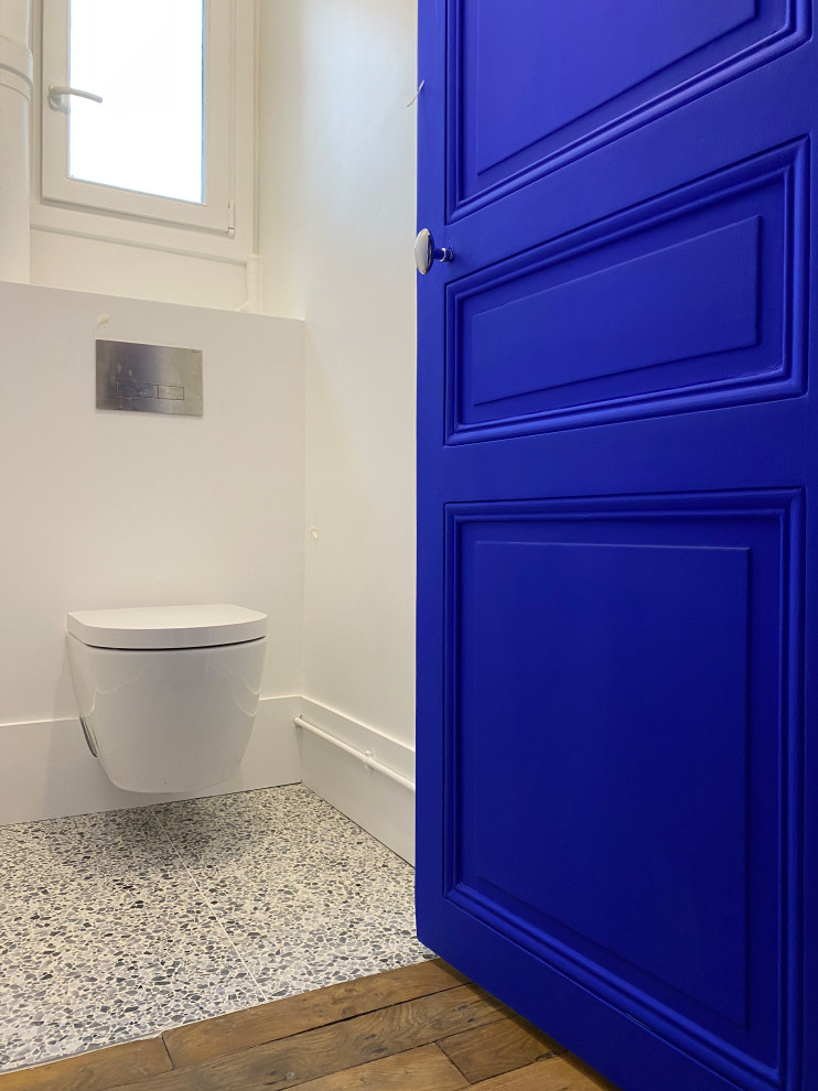 Moderne Gästetoilette mit Wandtoilette, blauer Wandfarbe, Terrazzo-Boden und weißem Boden in Paris