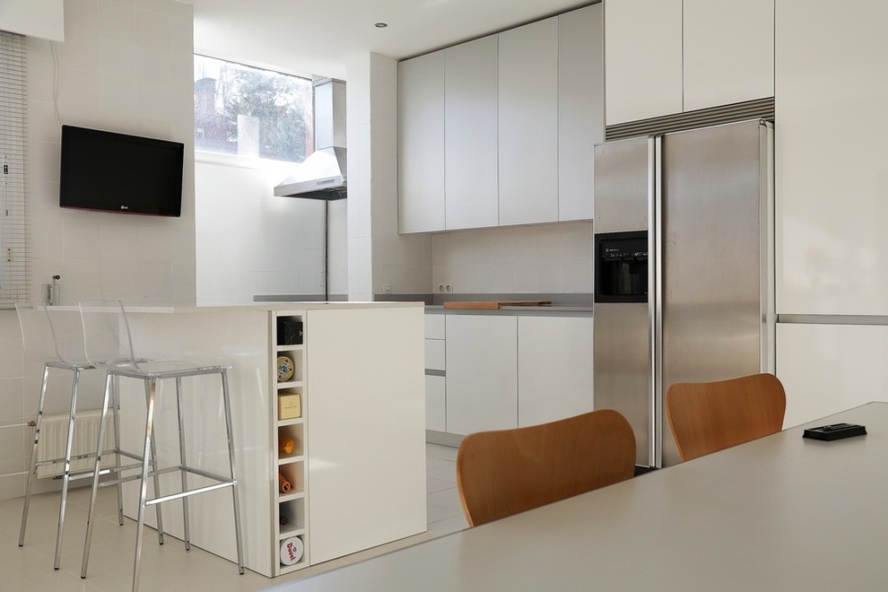 Design ideas for a large modern eat-in kitchen in Madrid with an undermount sink, flat-panel cabinets, white cabinets, quartzite benchtops, ceramic splashback, stainless steel appliances, ceramic floors and with island.