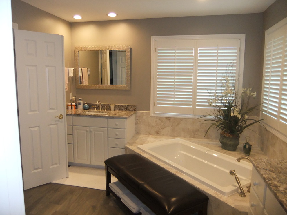 Design ideas for a mid-sized traditional master bathroom in Other with flat-panel cabinets, white cabinets, a corner tub, an alcove shower, a one-piece toilet, beige tile, ceramic tile, beige walls, dark hardwood floors, an undermount sink and granite benchtops.