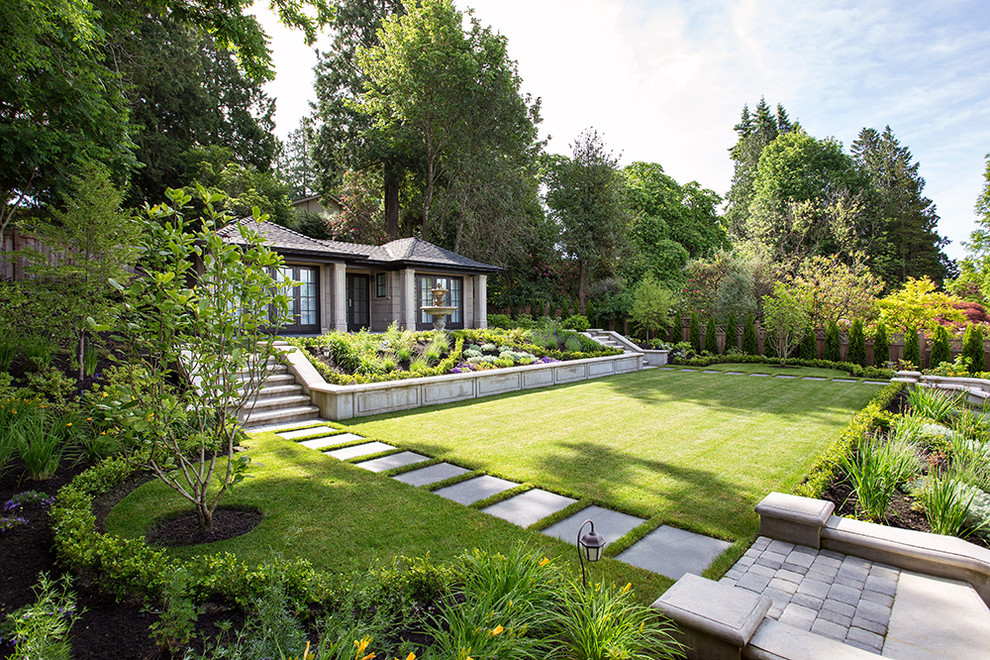 Photo of a large traditional sloped partial sun formal garden in Vancouver with brick pavers.
