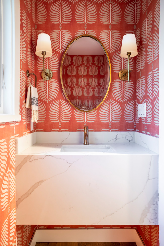Powder room - small transitional wallpaper, medium tone wood floor and brown floor powder room idea in San Francisco with marble countertops, white countertops, an undermount sink, a floating vanity and pink walls