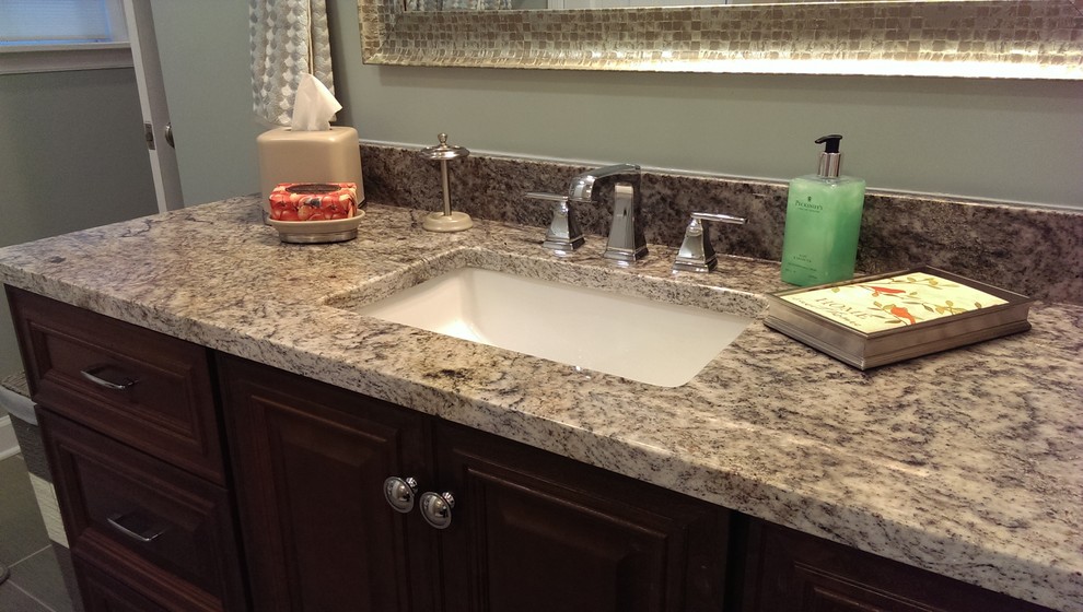 Mid-sized transitional bathroom in Atlanta with an undermount sink, raised-panel cabinets, medium wood cabinets, granite benchtops, an alcove shower, a two-piece toilet, beige tile, ceramic tile, grey walls and porcelain floors.