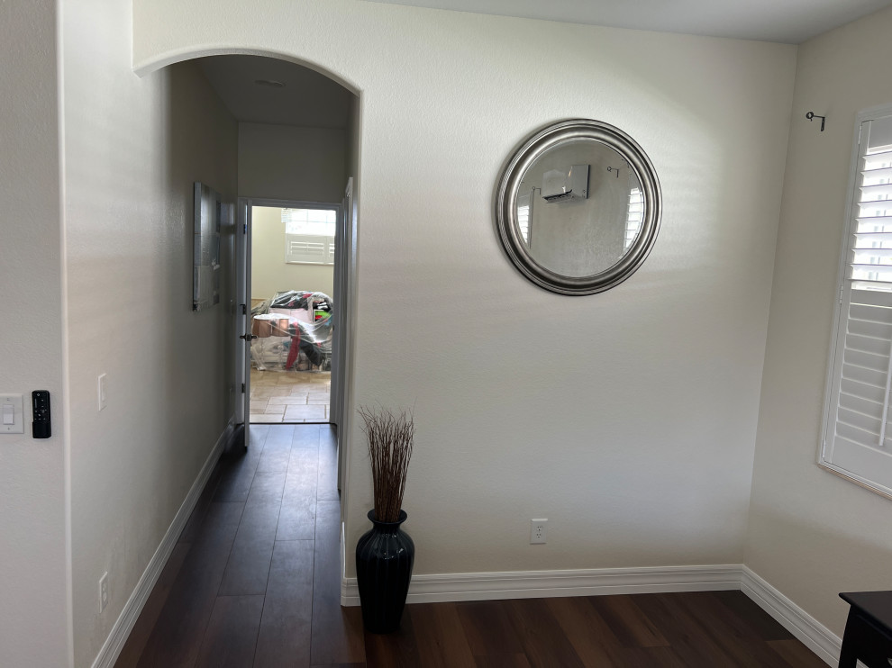 Photo of a small modern hallway in Miami with beige walls, vinyl floors and brown floor.