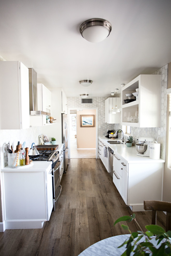 Photo of a small modern galley eat-in kitchen in Phoenix with a double-bowl sink, open cabinets, white cabinets, quartz benchtops, white splashback, marble splashback, stainless steel appliances, laminate floors, no island, beige floor and white benchtop.