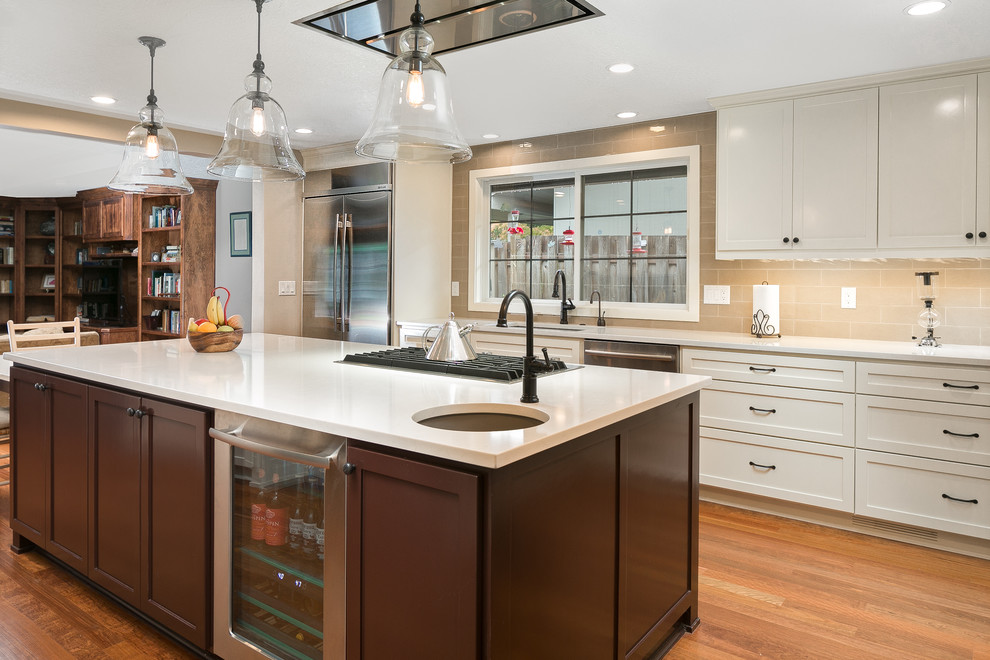 This is an example of a mid-sized contemporary u-shaped kitchen in Portland with an undermount sink, shaker cabinets, white cabinets, quartzite benchtops, beige splashback, stainless steel appliances, medium hardwood floors and a peninsula.
