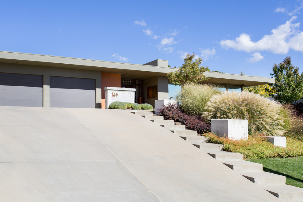 Photo of a large midcentury two-storey stucco multi-coloured house exterior in Salt Lake City with a flat roof.