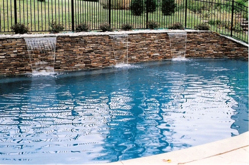 Example of a mid-sized backyard stone and custom-shaped lap pool fountain design in Baltimore