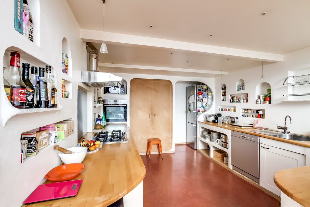 This is an example of a large eclectic galley kitchen in Paris with a drop-in sink, open cabinets, white cabinets and wood benchtops.