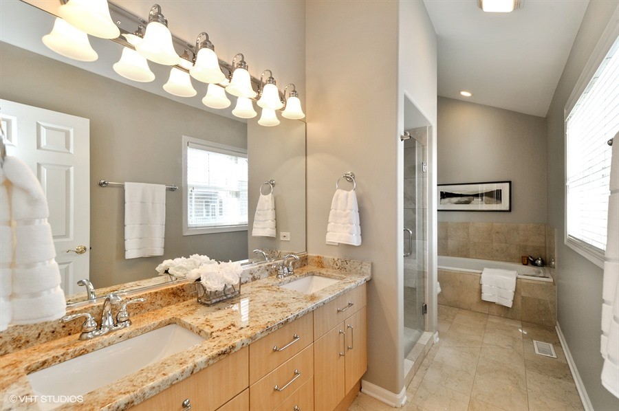 Mid-sized transitional master bathroom in Chicago with flat-panel cabinets, light wood cabinets, an alcove tub, an alcove shower, a two-piece toilet, beige tile, stone tile, grey walls, travertine floors, an undermount sink and granite benchtops.
