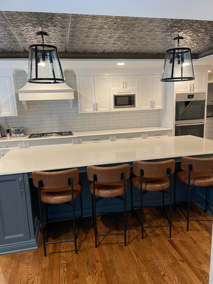 Kitchen - transitional kitchen idea in Omaha with blue cabinets, white backsplash, subway tile backsplash, stainless steel appliances and an island