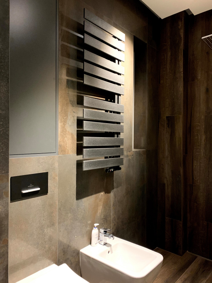 Inspiration for a medium sized contemporary cloakroom in Moscow with flat-panel cabinets, brown cabinets, a wall mounted toilet, brown tiles, ceramic tiles, brown walls, ceramic flooring, a vessel sink, wooden worktops, brown floors, brown worktops, feature lighting and a floating vanity unit.