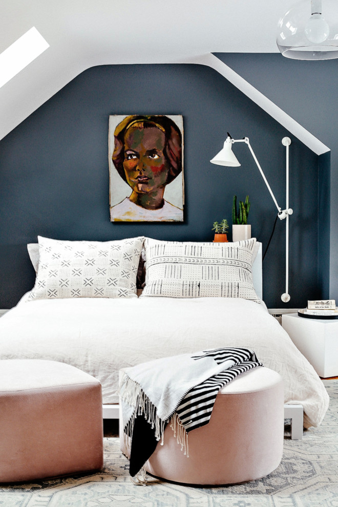 Photo of an eclectic guest bedroom in Portland Maine with blue walls and light hardwood floors.