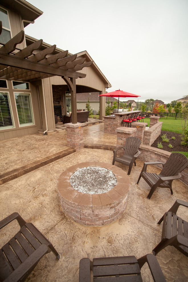 Inspiration for a modern backyard patio in Kansas City with a fire feature, stamped concrete and a pergola.