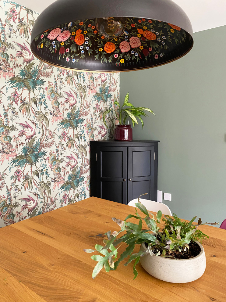 This is an example of a large eclectic open plan dining room in Other with green walls, medium hardwood flooring, no fireplace, brown floors, wallpapered walls and a feature wall.