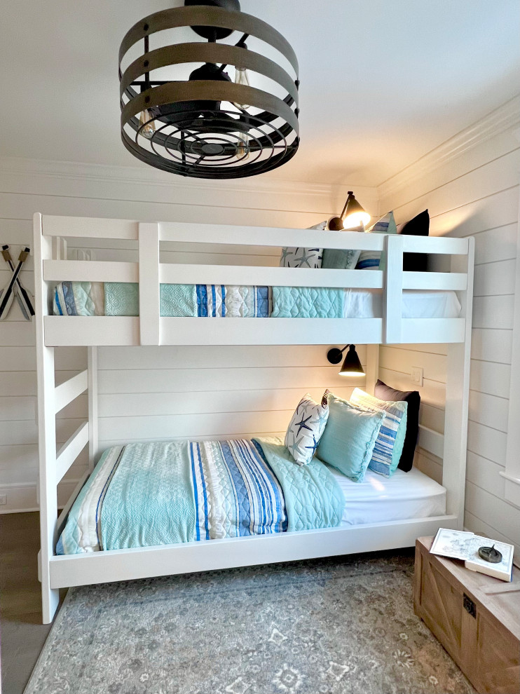 Immagine di una camera da letto costiera con pareti bianche, parquet chiaro, pavimento grigio e pareti in perlinato