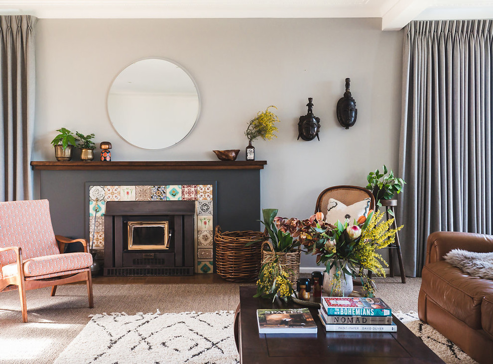 This is an example of a transitional living room in Melbourne with grey walls, medium hardwood floors, a standard fireplace, a tile fireplace surround and brown floor.