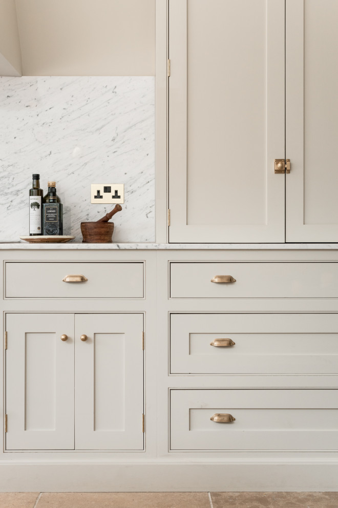Idéer för ett stort klassiskt vit linjärt kök med öppen planlösning, med en nedsänkt diskho, skåp i shakerstil, skåp i ljust trä, marmorbänkskiva, vitt stänkskydd, stänkskydd i marmor, svarta vitvaror, kalkstensgolv, en köksö och beiget golv