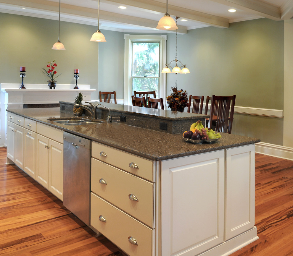 Design ideas for a mid-sized traditional l-shaped eat-in kitchen in Other with a double-bowl sink, raised-panel cabinets, white cabinets, laminate benchtops, stainless steel appliances, medium hardwood floors and with island.