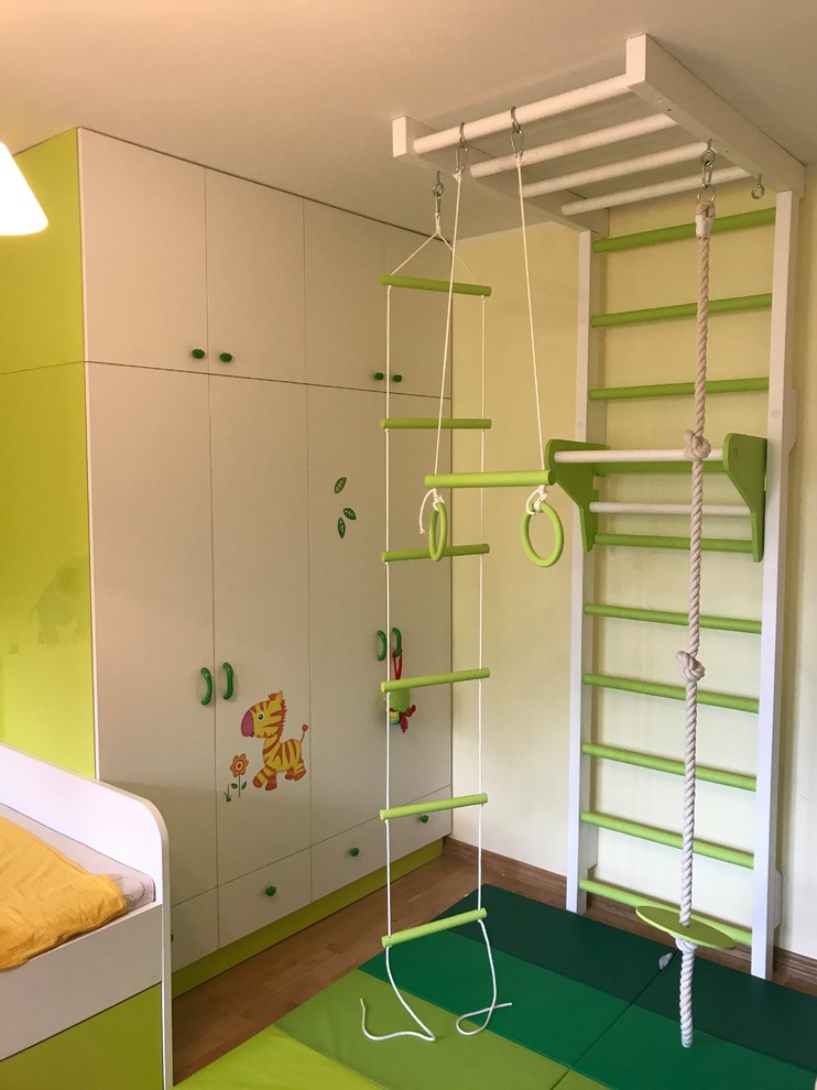 Design ideas for a large contemporary gender-neutral kids' playroom for kids 4-10 years old in London with white walls, light hardwood floors and beige floor.