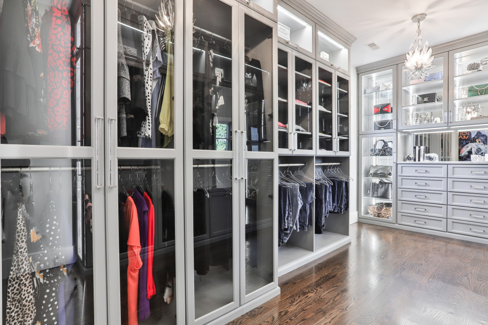 Large contemporary gender-neutral walk-in wardrobe in St Louis with shaker cabinets, grey cabinets, laminate floors and brown floor.