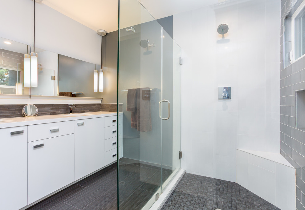 Mid-sized modern master bathroom in Orange County with flat-panel cabinets, white cabinets, a corner shower, a one-piece toilet, gray tile, porcelain tile, porcelain floors, an undermount sink, engineered quartz benchtops, white walls, grey floor, a hinged shower door and white benchtops.