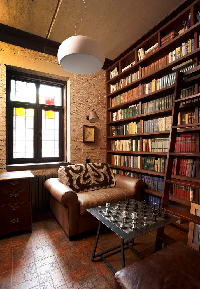 This is an example of an industrial home office in Moscow with a library, white walls and brown floor.