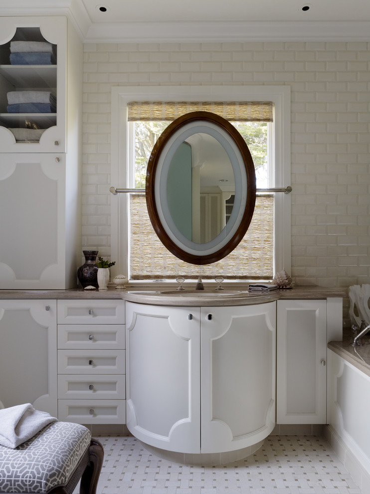This is an example of a contemporary bathroom in San Francisco with an undermount sink, white cabinets, beige tile and subway tile.