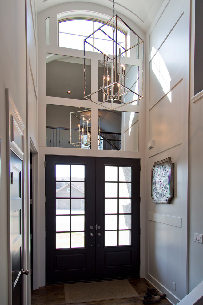 Design ideas for a large modern front door in Kansas City with white walls, medium hardwood floors, a double front door, a black front door and brown floor.