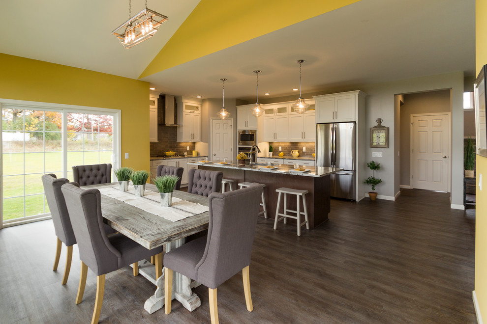 This is an example of a large transitional kitchen/dining combo in New York with yellow walls, medium hardwood floors and brown floor.