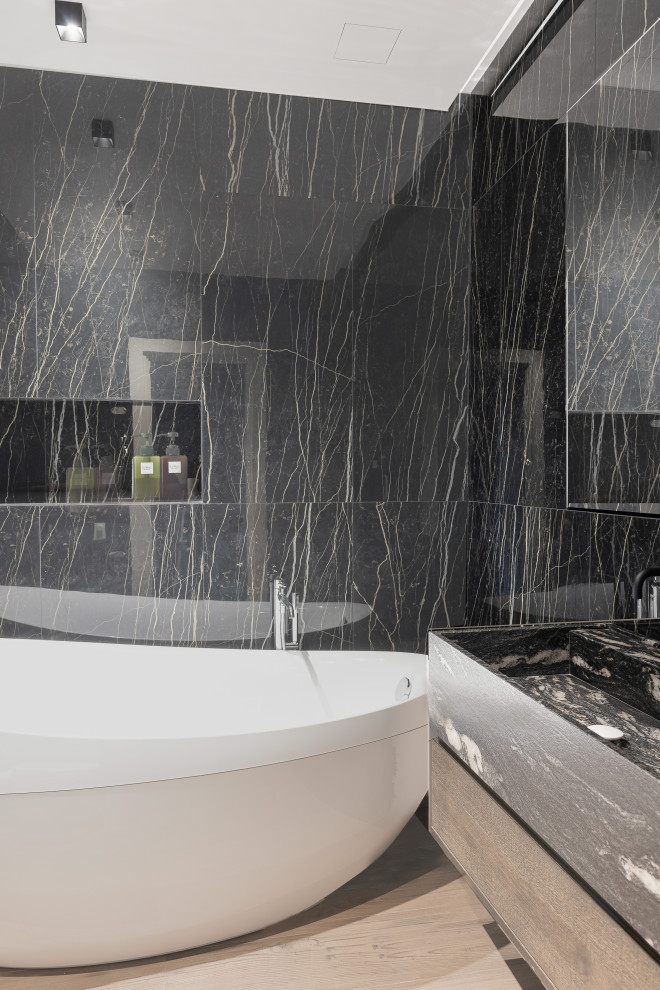 Exempel på ett mellanstort modernt svart svart en-suite badrum, med släta luckor, skåp i mellenmörkt trä, ett fristående badkar, en kantlös dusch, svart och vit kakel, porslinskakel, svarta väggar, klinkergolv i porslin, ett integrerad handfat, marmorbänkskiva och beiget golv