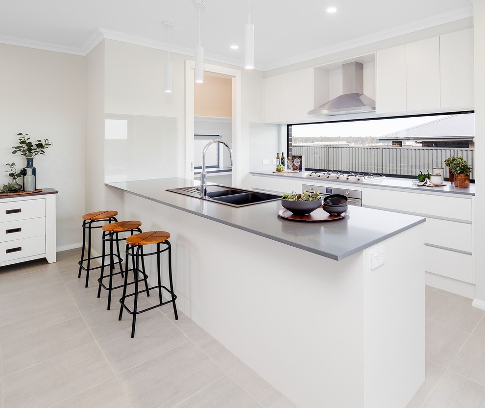 Mid-sized contemporary galley open plan kitchen in Sydney with a double-bowl sink, flat-panel cabinets, white cabinets, quartz benchtops, stainless steel appliances, ceramic floors, grey benchtop, window splashback, a peninsula and grey floor.