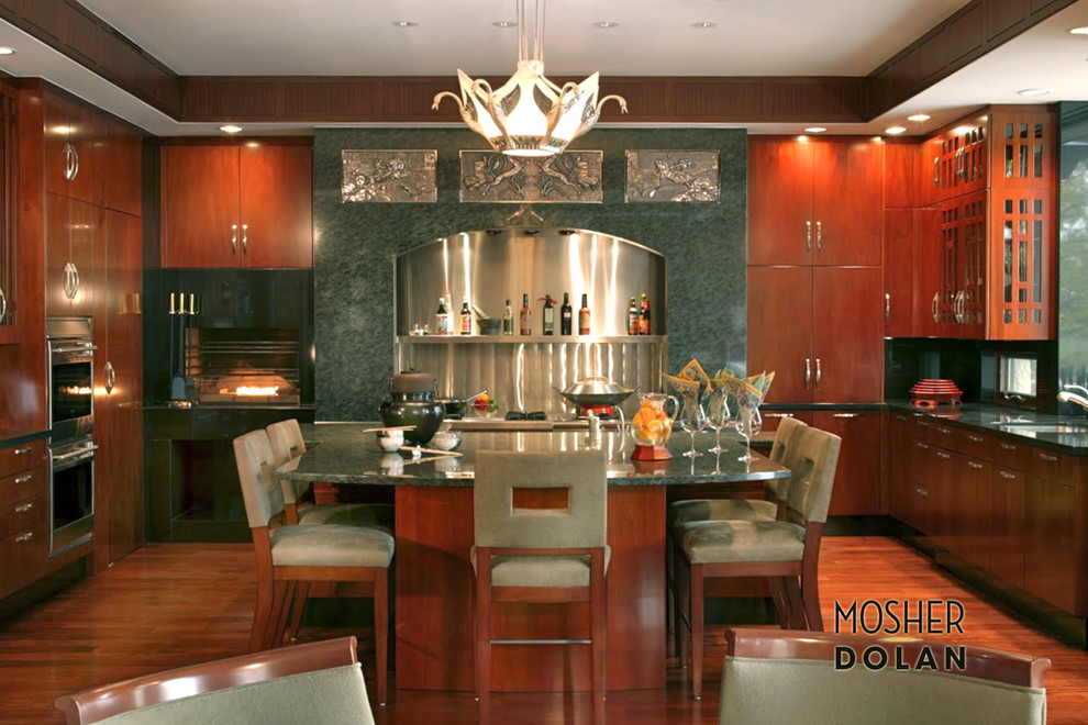 Example of a large u-shaped medium tone wood floor eat-in kitchen design in Detroit with an integrated sink, flat-panel cabinets, medium tone wood cabinets, soapstone countertops, metallic backsplash, stainless steel appliances and an island