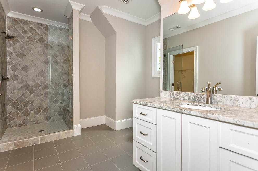 This is an example of a mid-sized traditional kids bathroom in Atlanta with an undermount sink, shaker cabinets, white cabinets, granite benchtops, a one-piece toilet, multi-coloured tile, ceramic tile, grey walls and ceramic floors.